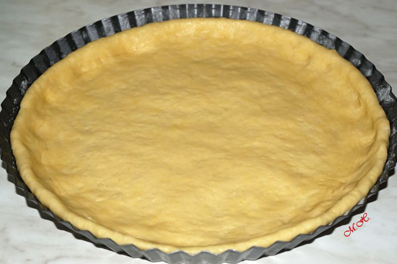 Rozprostřené těsto na koláč ve formě	