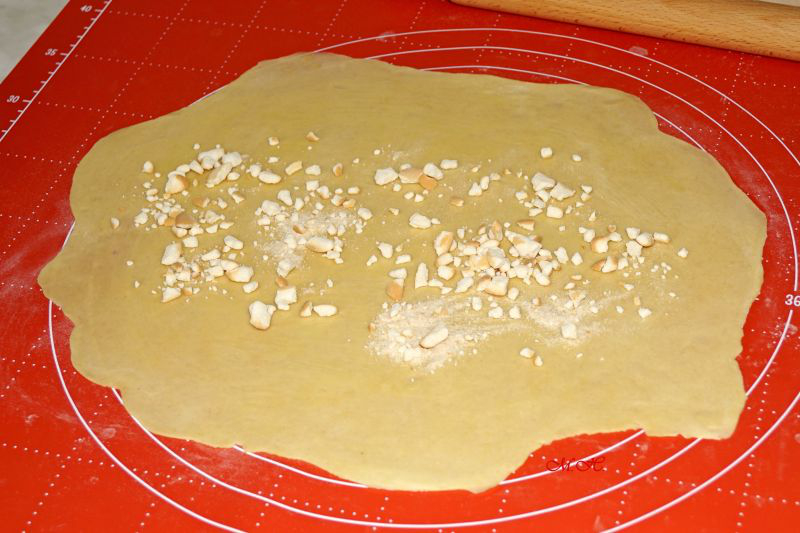 Rozválené těsto potřené máslem a posypané piškoty